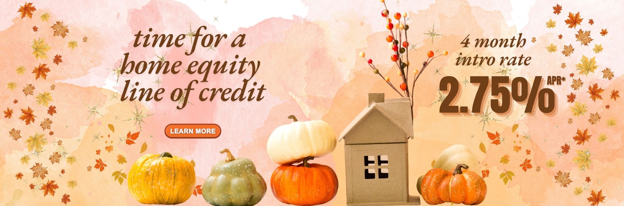 Small pumpkins and gourds with a brown paper house.